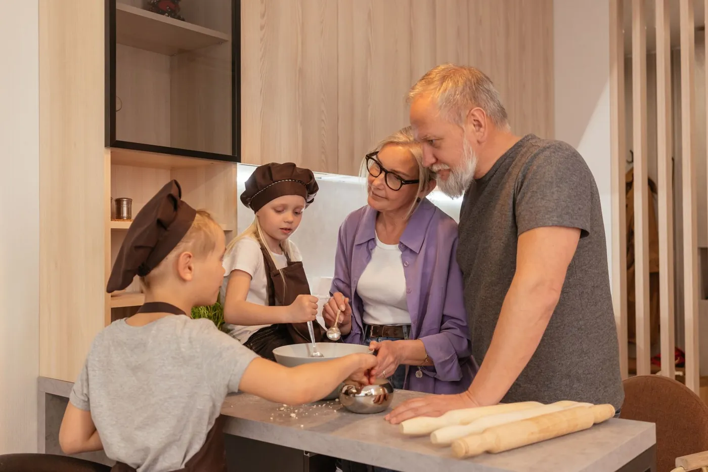 Family members cooking together at a home kitchen counter